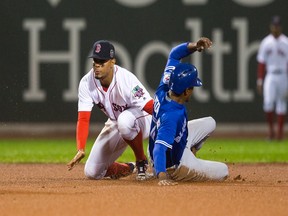 Toronto's Melvin Upton Jr. (right) avoids the tag of Boston's Xander Bogaerts in the fourth inning on Oct. 1.