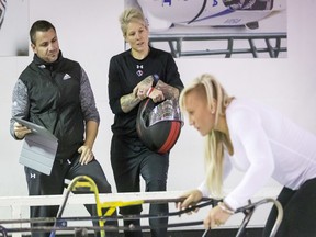 Canadian rugby star Jen Kish (centre) chats with Olympic bobsledder Kaillie Humphries (right) next to speed and strength coach Quin Sekulich at the WinSport Ice House in Calgary on Oct. 4.