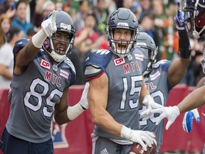 Montreal's Samuel Giguere (15) celebrates with Duron Carter after scoring a touchdown against the Toronto Argonauts on Oct. 2.