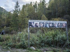 A sign showing ancient forms of humans welcoming visitors to the Cradle of Humanity Nature Park, which contains the Denisova cave, in Soloneshnoye, Russia, Sept. 20, 2016