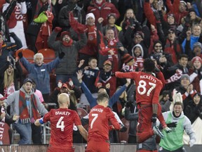 Toronto FC forward Tosaint Ricketts (87) celebrates with teammates Michael Bradley (4) and Will Johnson (7) after scoring against the New York City FC during second half MLS soccer playoff action in Toronto, Sunday, October 30, 2016.