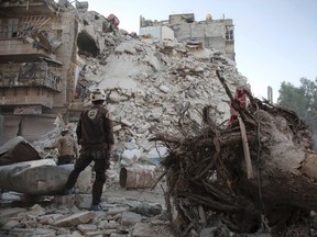 A member of the Syrian Civil Defence stands amid the rubble of a destroyed building during a rescue operation in Aleppo on Oct. 17.
