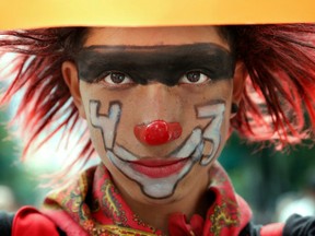A demonstrator dressed as a clown and the number 43 painted on her face poses for a photo during a protest march in Mexico City, Monday, Sept. 26, 2016.