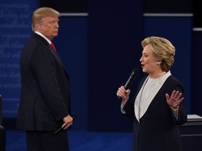 U.S. Democratic presidential candidate Hillary Clinton, right. speaks as U.S. Republican presidential candidate Donald Trump listens during the second presidential debate in St. Louis on Sunday.