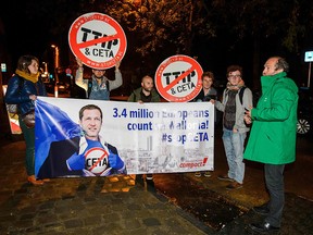 Protesters hold up a placard reading "3,4 million Europeans count on Wallonia — stop CETA" as a meeting on the Comprehensive Economic and Trade Agreement takes place at the Walloon parliament in Namur, Belgium, on Oct. 18, 2016.