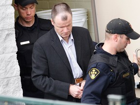 Former CFB Trenton commander and convicted serial killer Russell Williams is escorted from court in Belleville, Ont., a few moments after receiving a life sentence on Oct. 21, 2010.