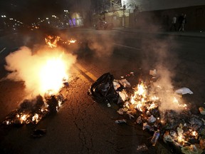 Multiple fires are lit in dumpsters and trash cans during protests in Oakland, Calif., late Tuesday, Nov. 8, 2016
