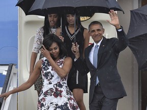 US President Barack Obama waves next to First Lady Michelle Obama (L) and their daughters Malia (L, behind) and Sasha upon their arrival at Jose Marti international airport in Havana on March 20, 2016.