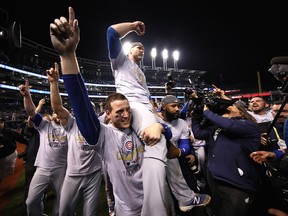 Anthony Rizzo, David Ross and Jason Heyward of the Chicago Cubs celebrate after defeating the Cleveland Indians 8-7 in Game Seven of the 2016 World Series.