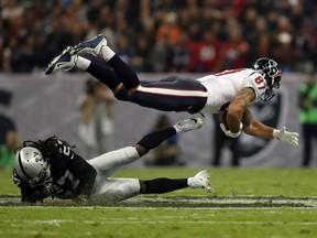 C.J. Fiedorowicz of the Houston Texans is tackled by Reggie Nelson of the Oakland Raiders in their game at Estadio Azteca on Monday in Mexico City, Mexico. The Raiders held on 27-20.