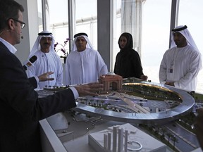 Rob Lloyd, the CEO of Hyperloop One, left, shows a model to Emirati officials including Mattar al-Tayer, the director-general and chairman of Dubai's Roads Transport Authority, third left, in Dubai, United Arab Emirates, Tuesday, Nov. 8, 2016.
