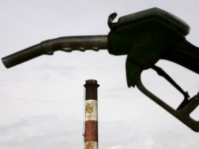 (FILES) This file photo taken on May 20, 2005 in Grandpuits-Bailly-Carrois, eastern Paris, shows the handle of a gas pump in front of an oil refinery of French giant Total.   French oil major Total said on September 22, 2016 it would cut back costs and investment in 2017-2018 in the face of continued low oil and gas prices. Total said it would cut annual investment to between $15 and 17 billion from next year instead of previous plans for $17-19 billion, and that it now intends to shave $4 billion from operating costs instead of $3 billion.  / AFP PHOTO / JOEL SAGETJOEL SAGET/AFP/Getty Images