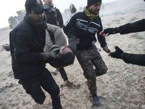 Members of the Iraqi Counter Terrorism Section carry an injured comrade during clashes with Islamic State jihadists near the village of Bazwaya, on the eastern edges of Mosul, on October 31, 2016.