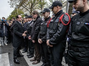 French President Francois Hollande shakes hand with anti-terrorist police forces next to the Bataclan concert in Paris on November 13, 2016, during a ceremony marking the first anniversary of the Paris terror attacks.
