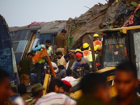 Indian rescue workers search for survivors in the wreckage of a train that derailed near Pukhrayan in Kanpur district on Sunday.