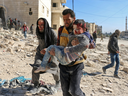 A Syrian civil defence volunteer, known as the White Helmets, carries a boy rescued from the rubble following a reported barrel bomb attack on the Bab al-Nairab neighbourhood of the northern Syrian city of Aleppo on November 24, 2016. 