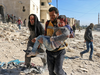 A Syrian civil defence volunteer, known as the White Helmets, carries a boy rescued from the rubble following a reported barrel bomb attack on the Bab al-Nairab neighbourhood of the northern Syrian city of Aleppo on November 24, 2016.