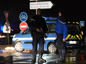 Gendarmes stand guard on a road near a retirement home for monks in Montferrier-sur-Lez, southern France, early on November 25, 2016, after an armed man burst in the home killing a woman with a knife.