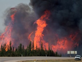 The Horse River Fire at its peak surges behind abandoned vehicles on  Alberta Highway 63 near Fort McMurray on Saturday, May 7, 2016.