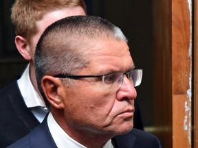 Russia's Economy Minister Alexei Ulyukayev is escorted before a hearing at the Basmanny district court in Moscow on November 15, 2016.