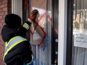 A worker cleans anti-Semitic graffiti, including a swastika, that was spray painted on the door of The Glebe Minyan and home of Rabbi Anna Maranta, on Nov. 15, 2016 in Ottawa.