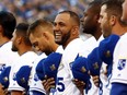 Kendrys Morales (smiling) and his Kansas City Royals teammates line the field for the National Anthem and a World Series Champion flag-raising ceremony at Kauffman Stadium on April 3, 2016.