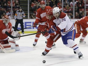 Detroit Red Wings defenseman Brendan Smith (2) and Montreal Canadiens left wing Phillip Danault (24) chase the puck next to Detroit Red Wings goalie Petr Mrazek (34) during the first period of an NHL hockey game, Saturday, Nov. 26, 2016, in Detroit. (AP Photo/Carlos Osorio)