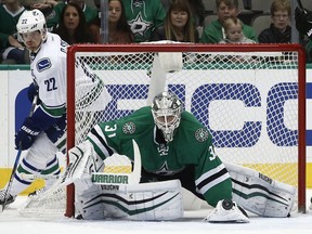 Dallas Stars goalie Antti Niemi scrambles for the puck as Vancouver Canucks forward Daniel Sedin looks for a rebound Friday during the Stars' 2-1 victory in Dallas.