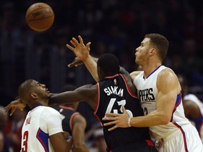 Pascal Siakam, centre. of the Toronto Raptors gets sandwiched in between Chris Paul, left, and Blake Griffin of the Los Angeles Clippers while battling for a loose ball during NBA action Monday night in Los Angeles. The Clippers emerged a 123-115 winner.