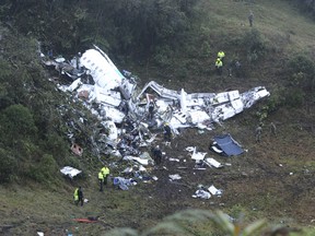 Police officers and rescue workers search for survivors around the wreckage of a chartered airplane that crashed in La Union, a mountainous area outside Medellin, Colombia, Tuesday, Nov. 29, 2016.