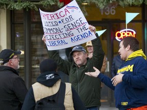 Donald J. Trump supporters, Mark Bowman, center, and Mike Bush, right, argue with protesters in opposition of Donald Trump's presidential election victory at Rosa Parks Circle in Grand Rapids, Mich.,  Thursday, Nov. 10, 2016.