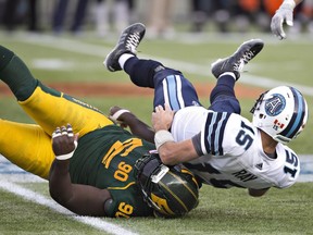 Toronto Argonauts quarterback Ricky Ray (right) is sacked by Edmonton Eskimos defensive lineman Almondo Sewell on Nov. 5.