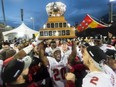 Laval Rouge et Or's Christopher Amoah hoists the Vanier Cup after defeating the Calgary Dinos to win the U Sports Vanier Cup football championship, in Hamilton on Saturday.