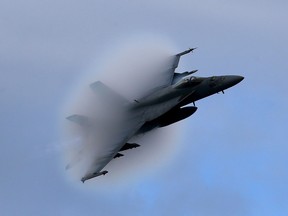 A F18 Super Hornet creates a vapour cone as it flies off Virginia in 2015. The federal Liberal government says it will "explore the acquisition" of 18 new Boeing-made Super Hornet jets on an interim basis until it can decide on a permanent replacement for Canada's aging fleet of fighter planes.