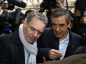 Francois Fillon, center, arrives with his bodyguard at his campaign headquarters in Paris, Monday, after emerging as the favourite to be France's conservative candidate for president in April