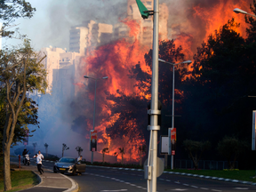 People run as wildfires rages in Haifa, Israel, Thursday, Nov. 24, 2016.