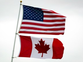 U.S. and Canadian flags fly in Point Roberts, Wash., on Tuesday, March 13, 2012. At the watering hole where Canadian expats gather in the U.S. capital, a group of boisterous Canucks involved in international affairs came not to praise the Conservative government ??? but to bury it. THE CANADIAN PRESS/Darryl Dyck