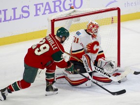 Minnesota Wild's Jason Pominville looks for a rebound from Calgary Flames goalie Chad Johnson during the first period of their game Tuesday night in St. Paul, Minn.