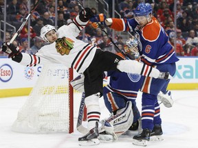 Chicago Blackhawks forward Marcus Kruger is pushed out of Edmonton Oilers goaltender Cam Talbot's crease by defenceman Adam Larsson on Nov. 21.