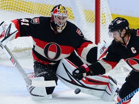 Ottawa defenceman Erik Karlsson reaches for the puck as Craig Anderson prepares to make the save in a 3-1 victory over the Boston Bruins Thursday in Ottawa.