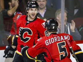 Michael Frolik, left, celebrates his game-winning overtime goal with Flames teammate Mark Giordano during NHL action against the Arizona Coyotes in Calgary on Wednesday night.
