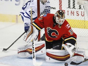 Calgary Flames' goalie Chad Johnson stops a breakaway shot by Toronto Maple Leafs' Mitchell Marner, left, during third period in Calgary on Wednesday. The Flames won 3-0.