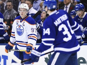 Edmonton Oilers centre Connor McDavid and Maple Leafs centre Auston Matthews skate during a break in first period NHL action in Toronto on Tuesday night.