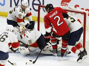 Florida Panthers goaltender Roberto Luongo keeps his eye on the puck in a crowd in front of his net, including Senators defenceman Dion Phaneuf, during their game Saturday night in Ottawa.