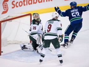 Vancouver Canucks' Bo Horvat, right, celebrates Sven Baertschi's second goal as Minnesota Wild goalie Darcy Kuemper, left, and Mikko Koivu, look on during the third period in Vancouver on Tuesday.