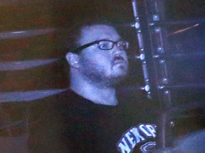 In this Monday, Nov. 10. 2014, file photo taken through tinted glass, Rurik Jutting, a British banker, is escorted in a prison bus to a court in Hong Kong