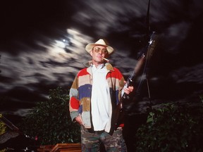 unter S. Thompson stands on the balcony of his home at midnight with one of his pet peacocks beside him September 1990 in Woody Creek, CO.