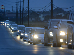Vehicles make a line as they flee following a tsunami warning in Iwaki, Fukushima prefecture early Tuesday, Nov. 22, 2016.