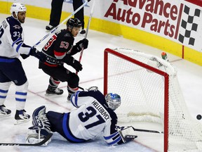 Carolina Hurricanes' Jeff Skinner has his shot deflected over the net by goalie Connor Hellebuyck  with Dustin Byfuglien  nearby during the third period Sunday in Raleigh, N.C. The Hurricanes won 3-1.