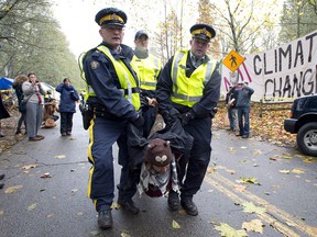RCMP officers take protesters into custody at an anti-pipeline demonstration in Burnaby, B.C., on Nov. 20, 2014. The Liberal government’s approval of the Kinder Morgan Trans Mountain pipeline has sparked outrage — and praise from business groups.